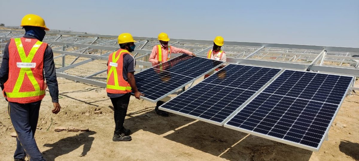 Crew installing solar panels on site